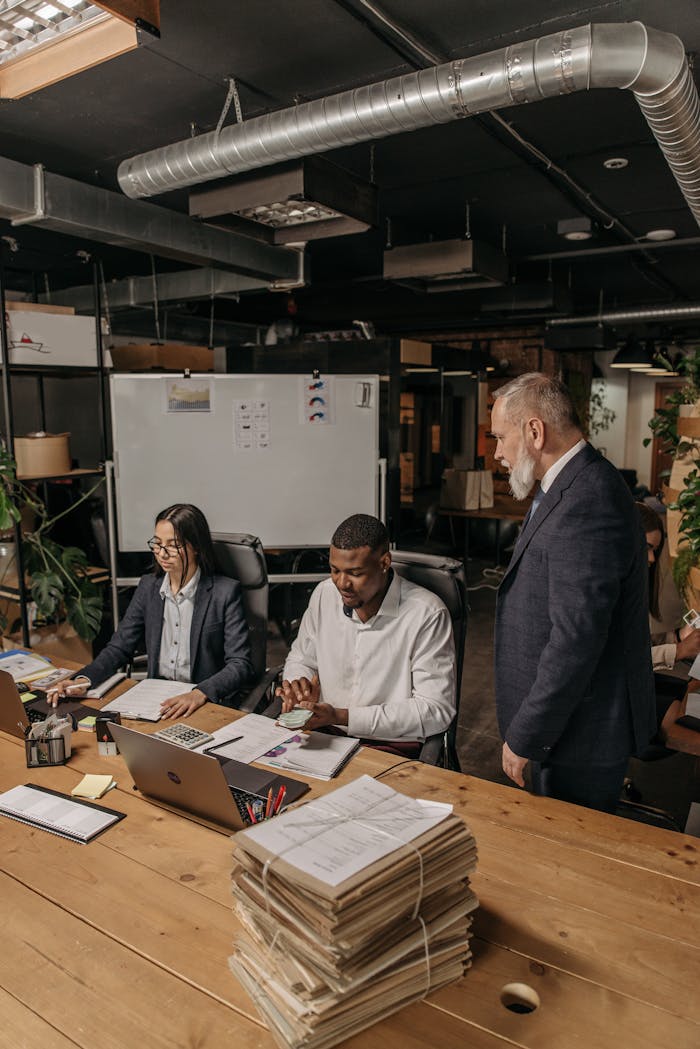A diverse team collaborating in a modern office setting, reviewing documents and reports.